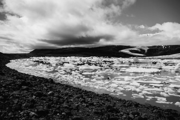 View of the glacier tongue Fjallsjökull with its icebergs and the glacier lagoon Fjallsárlón in Iceland. With a view of Öræfajökull in the background.
