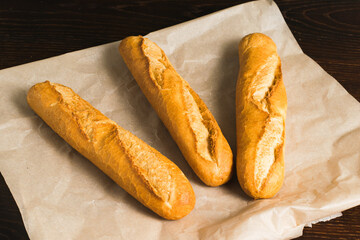Delicious baguettes close-up, on baking paper. Concept of development of craft bakeries