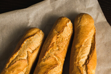 Delicious baguettes close-up, on baking paper. Concept of development of craft bakeries