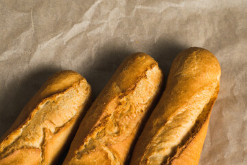 Delicious baguettes close-up, on baking paper. Concept of development of craft bakeries