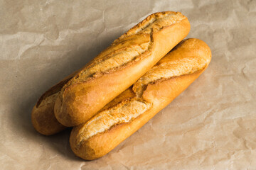 Delicious baguettes close-up, on baking paper. Concept of development of craft bakeries