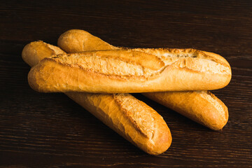 French baguettes with appetizing crusts on a wooden background close-up