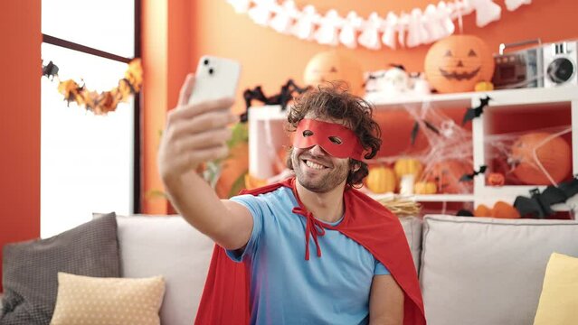 Young hispanic man make selfie by smartphone having halloween party at home