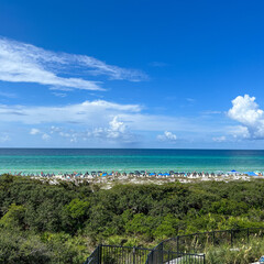 An aerial view of the Beach with Blue Umbrella and Lounge Chairs lined up at the Watercolor Community Club in Watercolor, Florida.