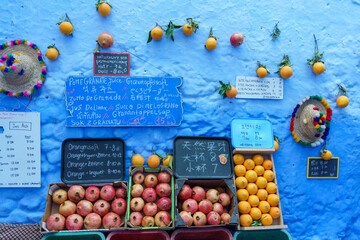 North Africa. Morocco. Chefchaouen. Fruits for sale in front of a decorated blue wall