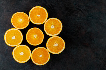Halves of ripe oranges on a dark background. Sliced oranges for breakfast. Copy space