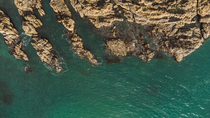 Ocean meets jagged cliff