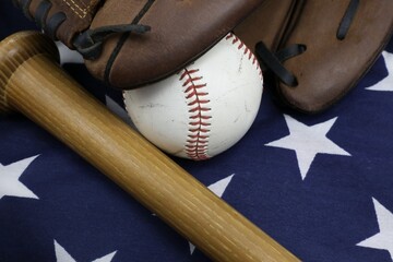 wood baseball bat, glove, and ball with Stars and Stripes background