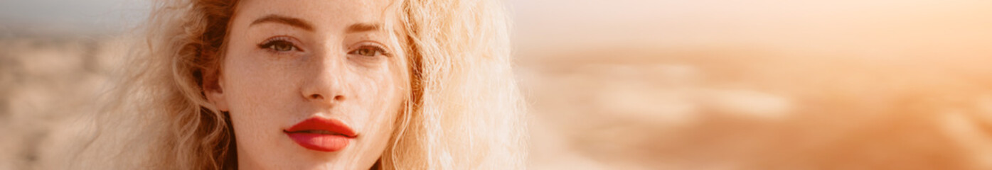 Women's eyes banner. Close up portrait of curly redhead young caucasian woman with freckles at sunset time. Cute woman portrait.