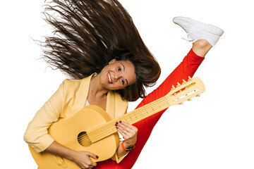 Young attractive brunette girl dressed in yellow jacket and red pants holding yellow guitar dancing...
