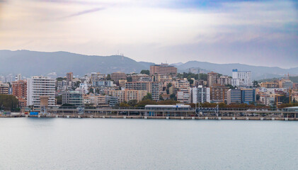 Naklejka premium Mallorca, Spain - October 22, 2022, Port Alcudia in the early evening, view of the city from the sea in Mallorca