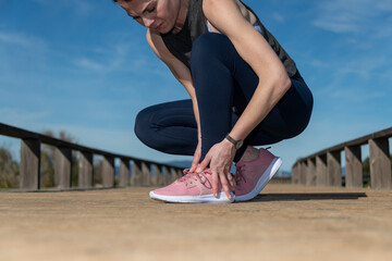 Painful running injury. Detail of runner holding her ankle.
