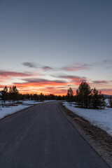 Fototapeta na wymiar sunset on the road with snow