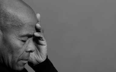 man praying to god with hands together with black grey background with people stock photo 