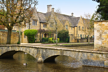 Idyllic Cotswolds village of Bourton on the Water with bridge and stone houses along the River...