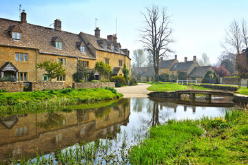 Fototapeta na wymiar Cotswolds village of Lower Slaughter with beautiful morning reflections and bridge, England