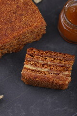 Honey cake. classic honey cake. on a dark slate or concrete background. Cut and slice of cake. The concept of home baking
