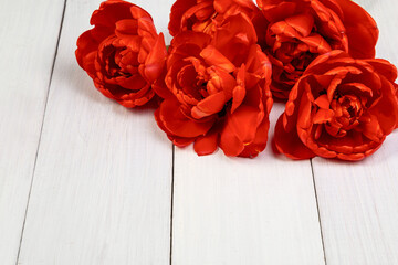 Bouquet of red tulips on a light wooden background. Copy space
