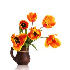 Bouquet of bright tulips in a clay jug isolated on a white background. Copy space