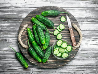 Pieces of cucumbers in a bowl on a cutting Board with a knife.