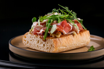 delicious crispy bruschetta with chopped pieces of jamon and arugula leaves