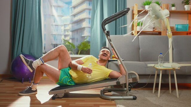 lazy funny athlete with a mustache lies treadmill in the living room