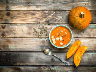 Pumpkin soup in bowl with spoon.