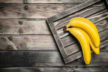 Whole juicy bananas on black dressing.