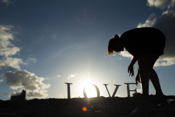 girl with a love sign in the sand