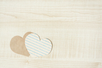 Two craft paper hearts on light wooden background. Hopeless romantic aesthetic, Flatlay, top view. Template on Valentines day.