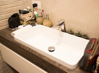 Sink in a luxury bathroom. There is some mess. Home lived concept.