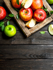 Red and green apples in a wooden box.