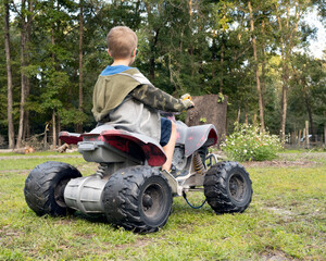 A young boy on an electric ATV in the yard
