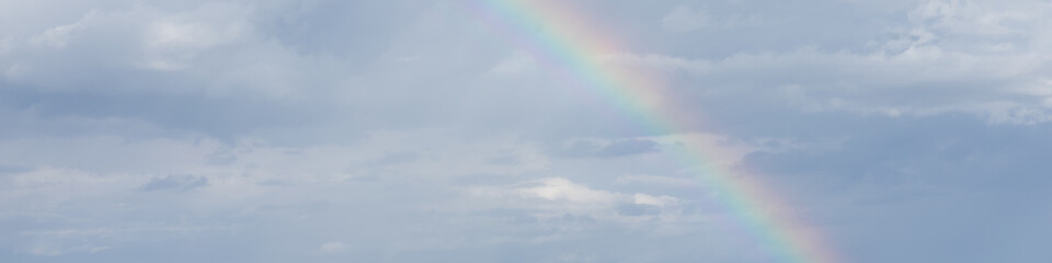 4x1 banner with a rainbow in the cloudy sky after the rain
