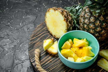 Cut fresh pineapple in bowl on tray.