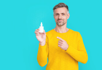 man hold nasal medicine on background, point finger. photo of man hold nasal medicine.