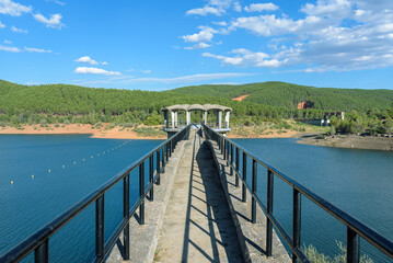 Scenic landscape of water reservoir of El Vado among mountains on a day with blue sky and clouds, Guadalajara, Spain