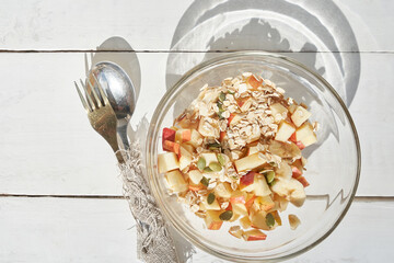 Fitness nutrition, for a slim figure. Close-up of a healthy fruit salad in a glass bowl with slices of apple, banana with pumpkin seeds and oatmeal. High quality photo