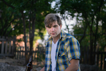A young white man outdoors in a shady backyard setting