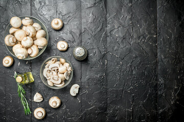Fototapeta na wymiar Fresh mushrooms in a bowl, bottled oil and pepper.