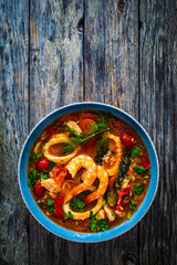 Seafood and fish soup on wooden table
