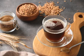 Selbstklebende Fototapeten Cafe Barley coffee in glass cup, beans and ears of barley on brown background. Natural caffeine free organic coffee alternative. Beverage made of healthy blend of roasted barley. Close up. Copy space.  © svetlana_cherruty