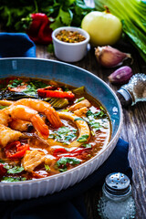 Seafood and fish soup on wooden table
