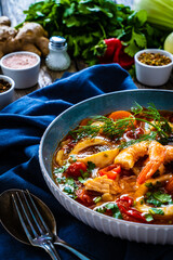 Seafood and fish soup on wooden table
