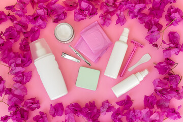 Women's personal care products on a pink background. Pads, razor, cream, spray, tweezers.