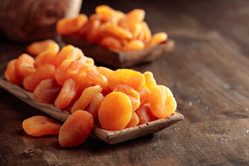 Dried apricots in a wooden dish.