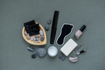 Cosmetic products for personal care on a gray background. Cream, soap, comb, tweezers, pumice...