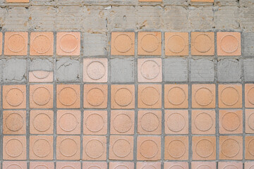 Big shabby textured wall is lined with old Soviet beige and terracotta crumbling ceramic tiles....