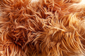 Close up brown synthetic fur, wool texture background. Fluffy and soft faux skin sheep. Light natural, top view. Concept of comfort.