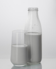 glass bottle and glass with milk on white background